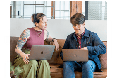 Two people working together on laptops