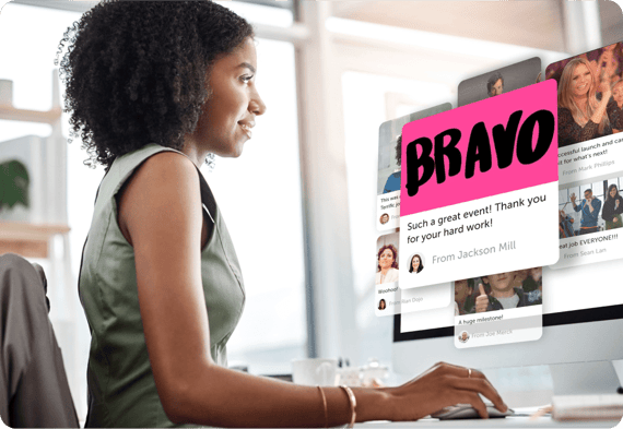 Woman smiling while opening Kudoboard on desktop computer