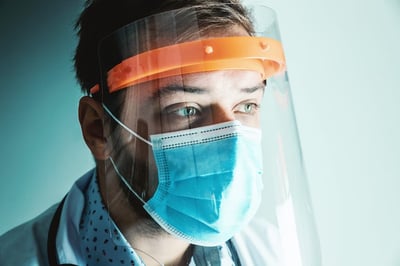 Close up of healthcare worker wearing mask and face shield