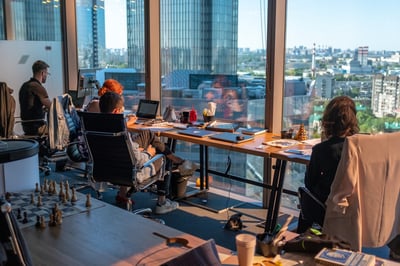 Group of employees working on table in front of open window