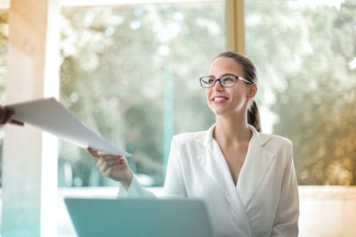 Office worker smiling and handing off file