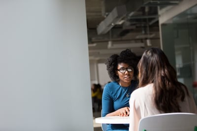 Two people talking at small table