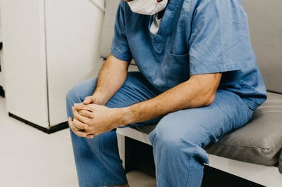 Healthcare worker wearing mask and sitting