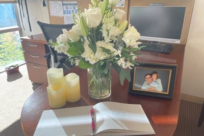 Sympathy flowers on desk and book with pen