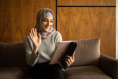 Person on couch waving to iPad