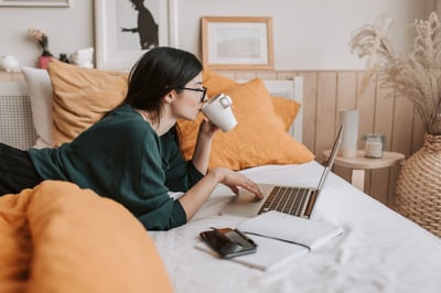 Person working on laptop on bed