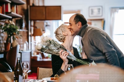 Person getting flowers and a kiss on the cheek