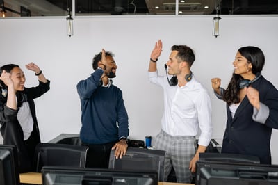 Two workers high-fiving in office