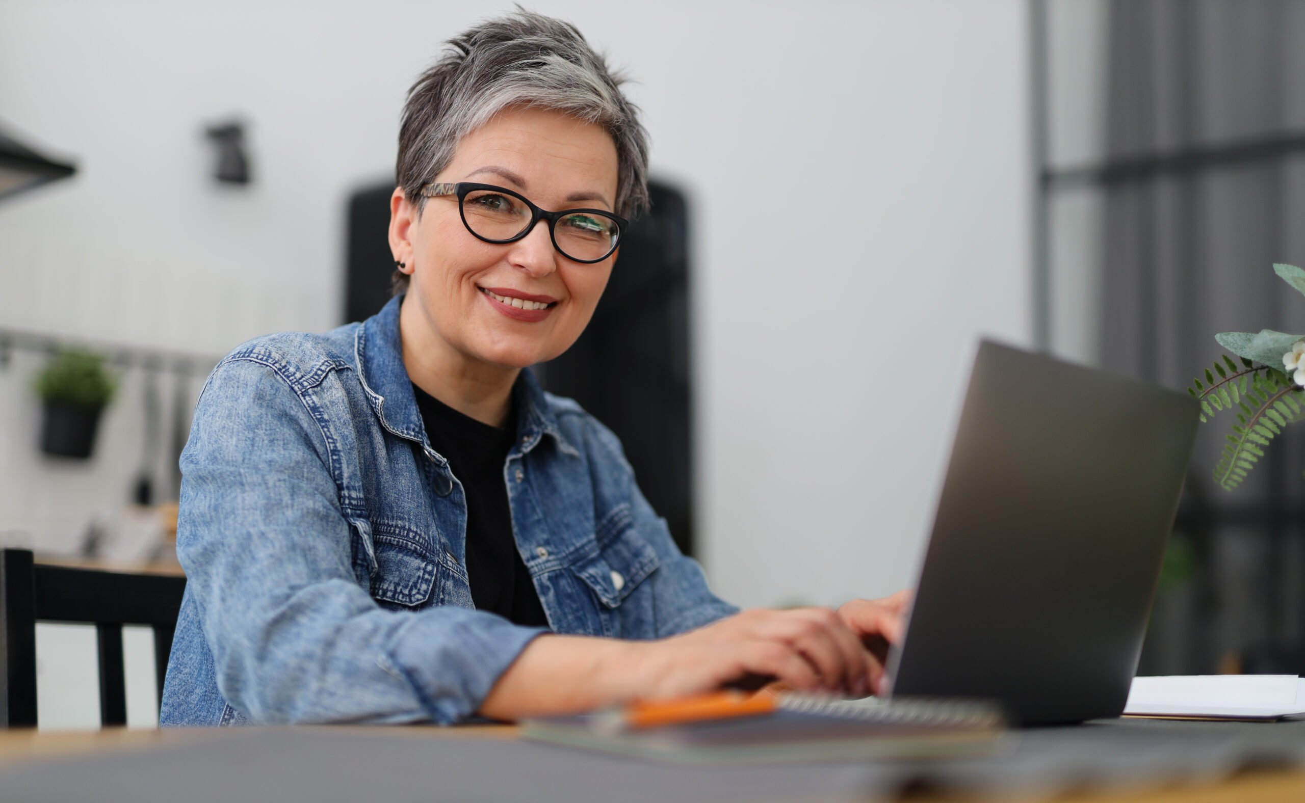 Retired woman leaving retirement wishes on a laptop