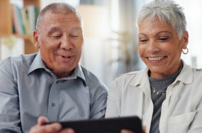 Retirees looking a retirement wishes on a tablet