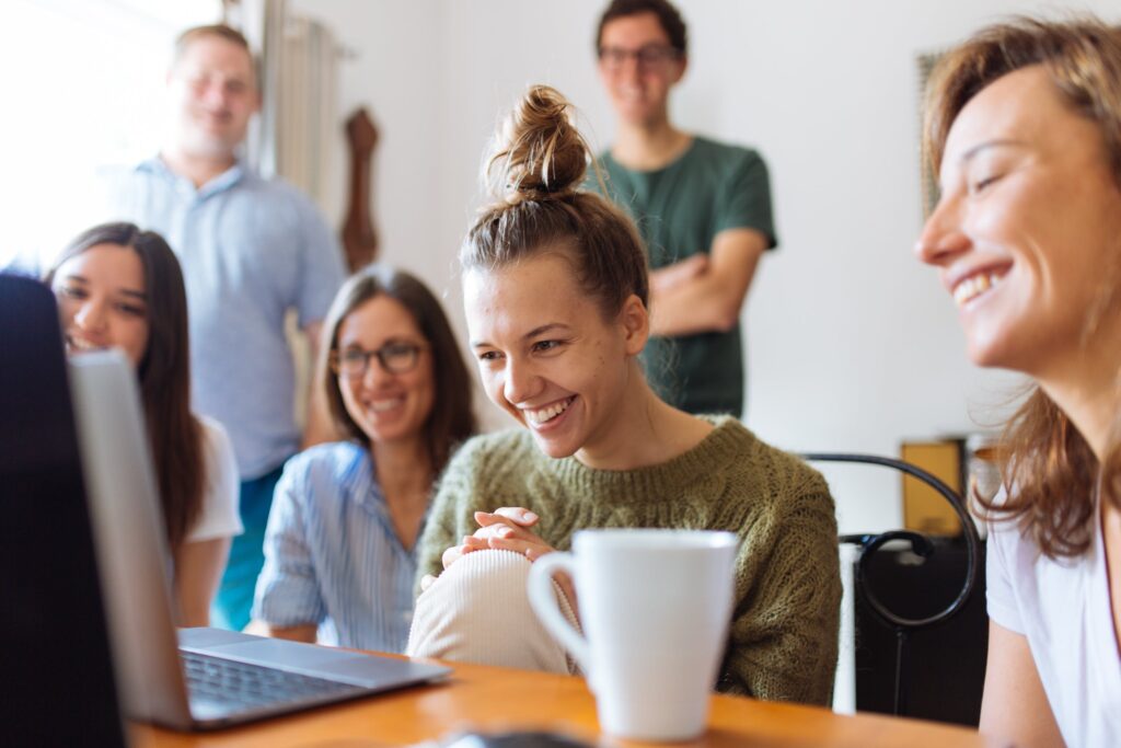 people smiling and enjoying content on laptop