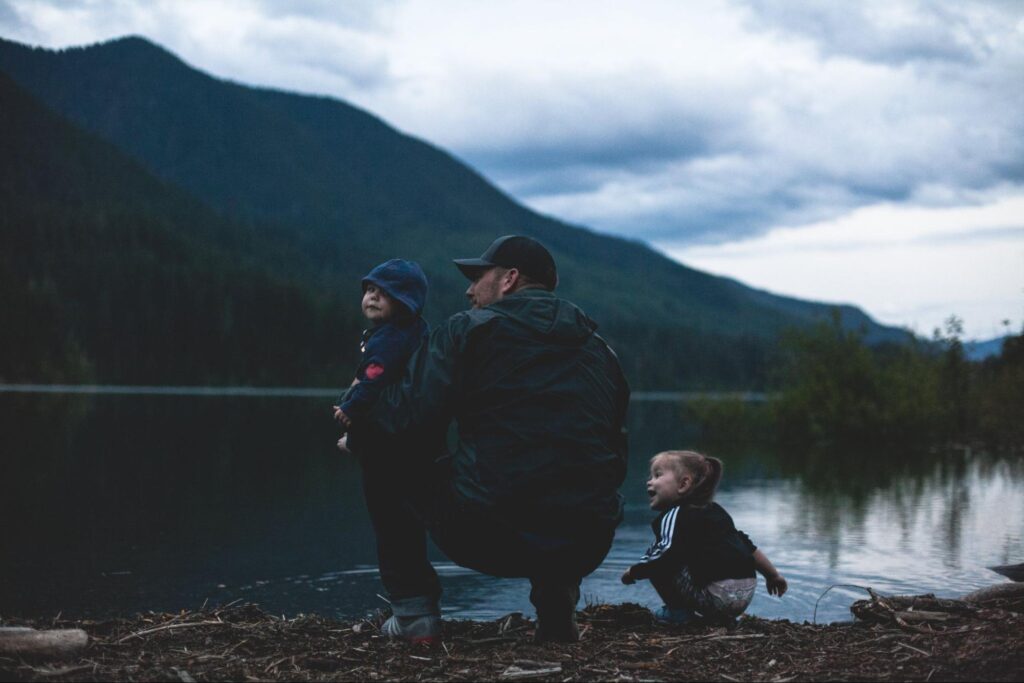 Dad spending time with two small children at lake