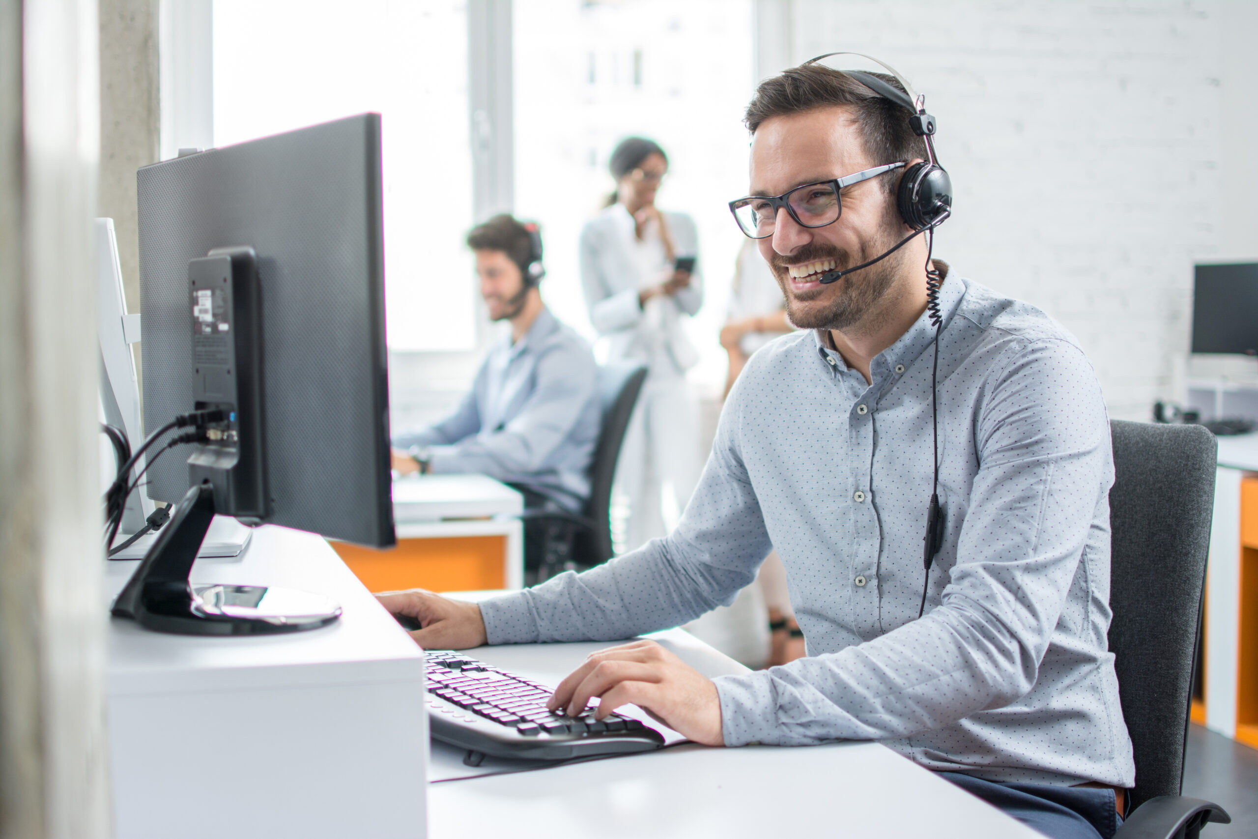 Smiling customer support agent working on laptop