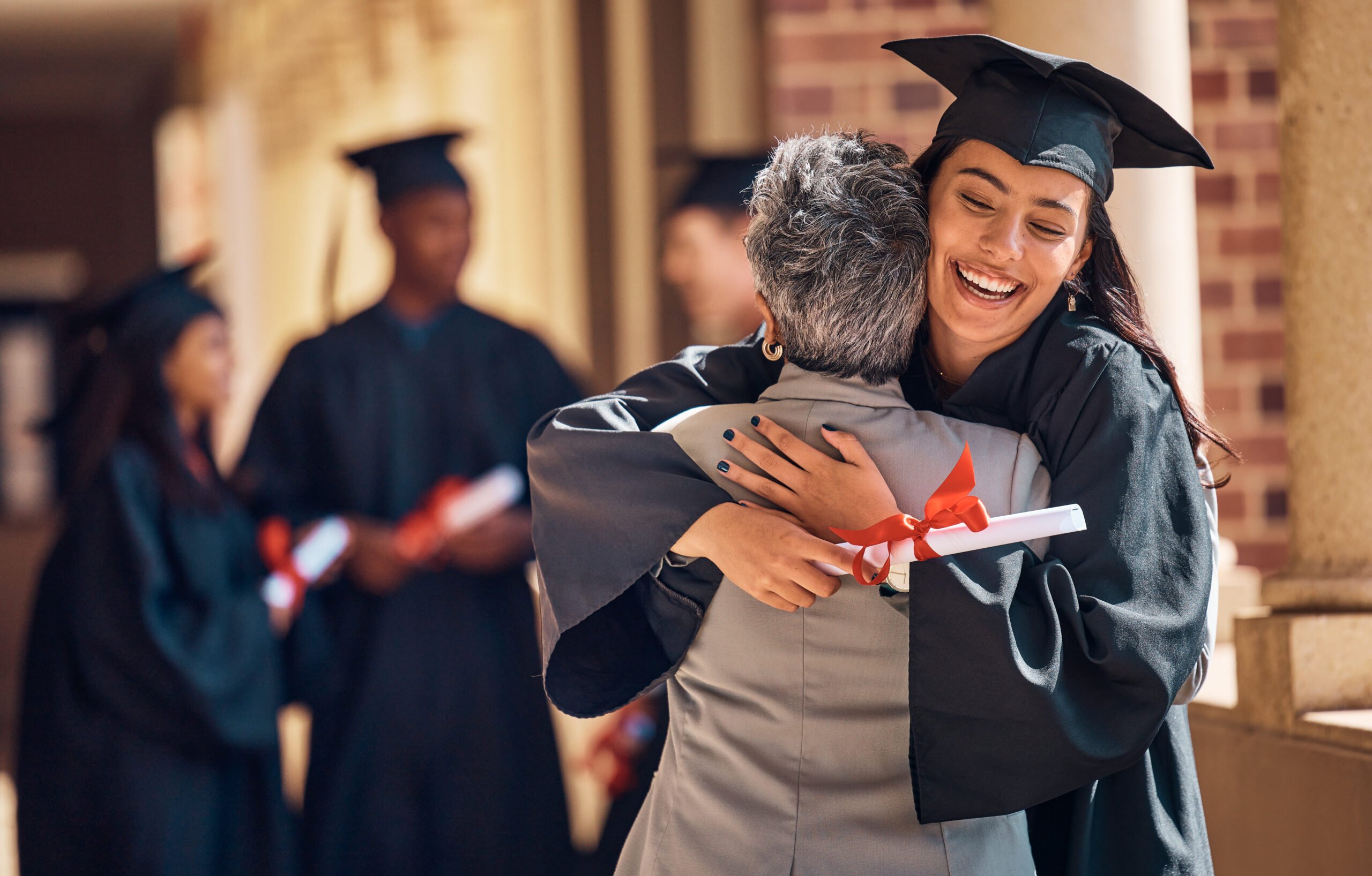 Older person hugging a graduate wearing a cap