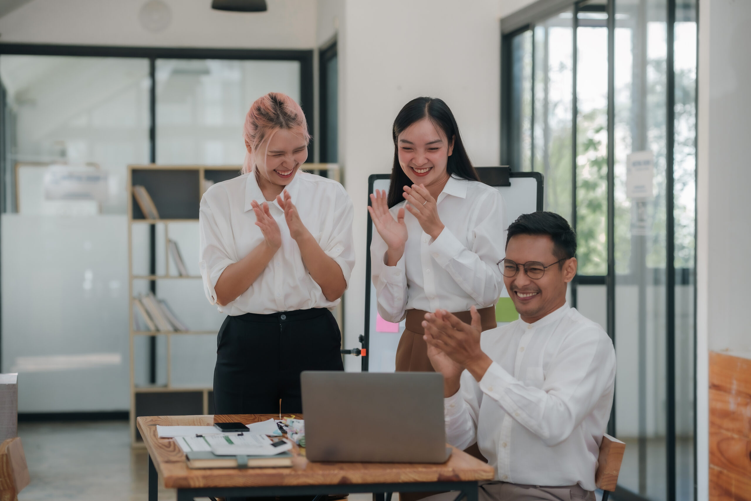 Employees clapping and celebrating success in office