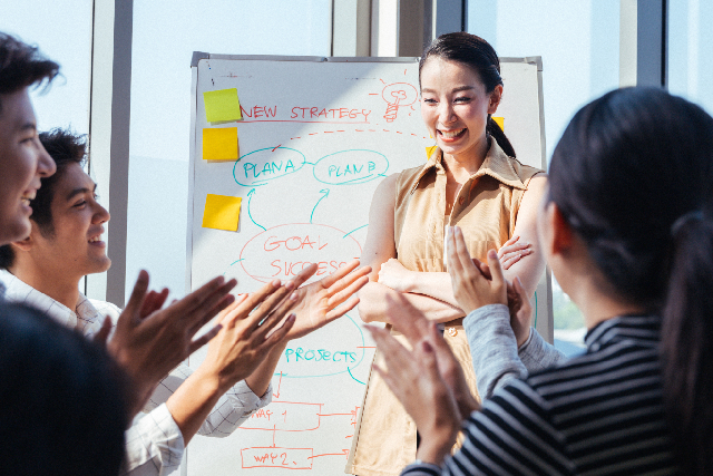 Person being applauded after presenting an employee recognition plan