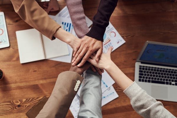 Employees putiing hands together in a circle