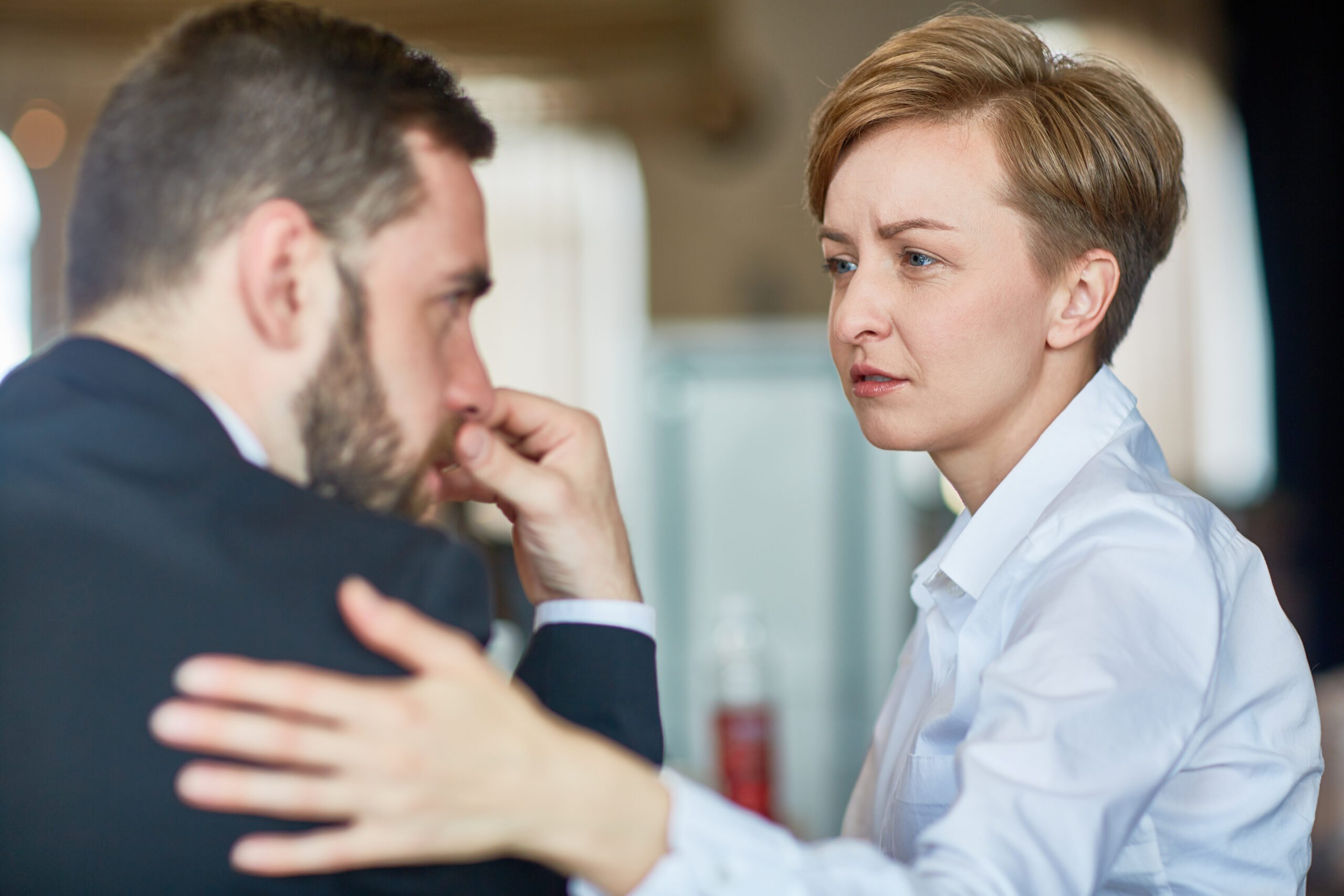 employee offering condolences messages with hand of back of coworker