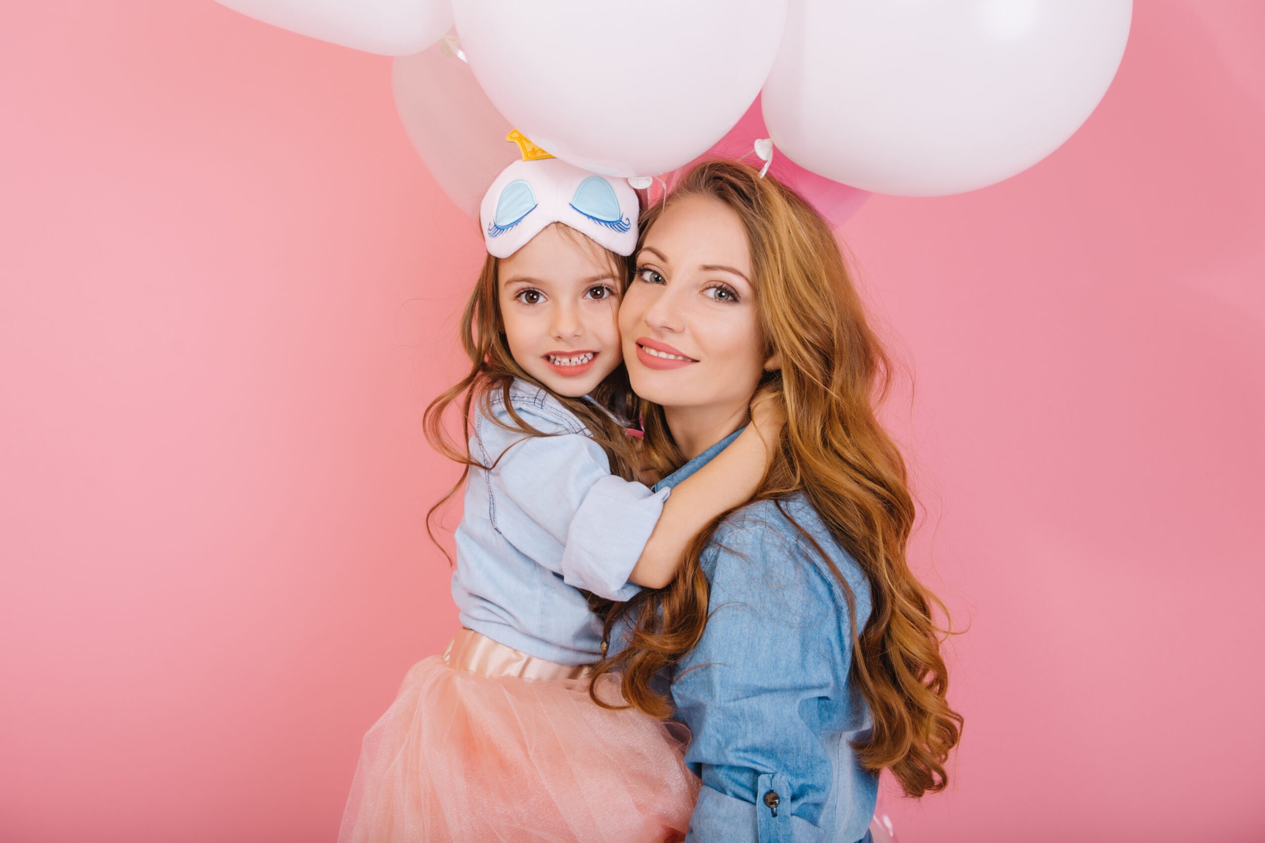 Mom and daughter hugging with birthday balloons