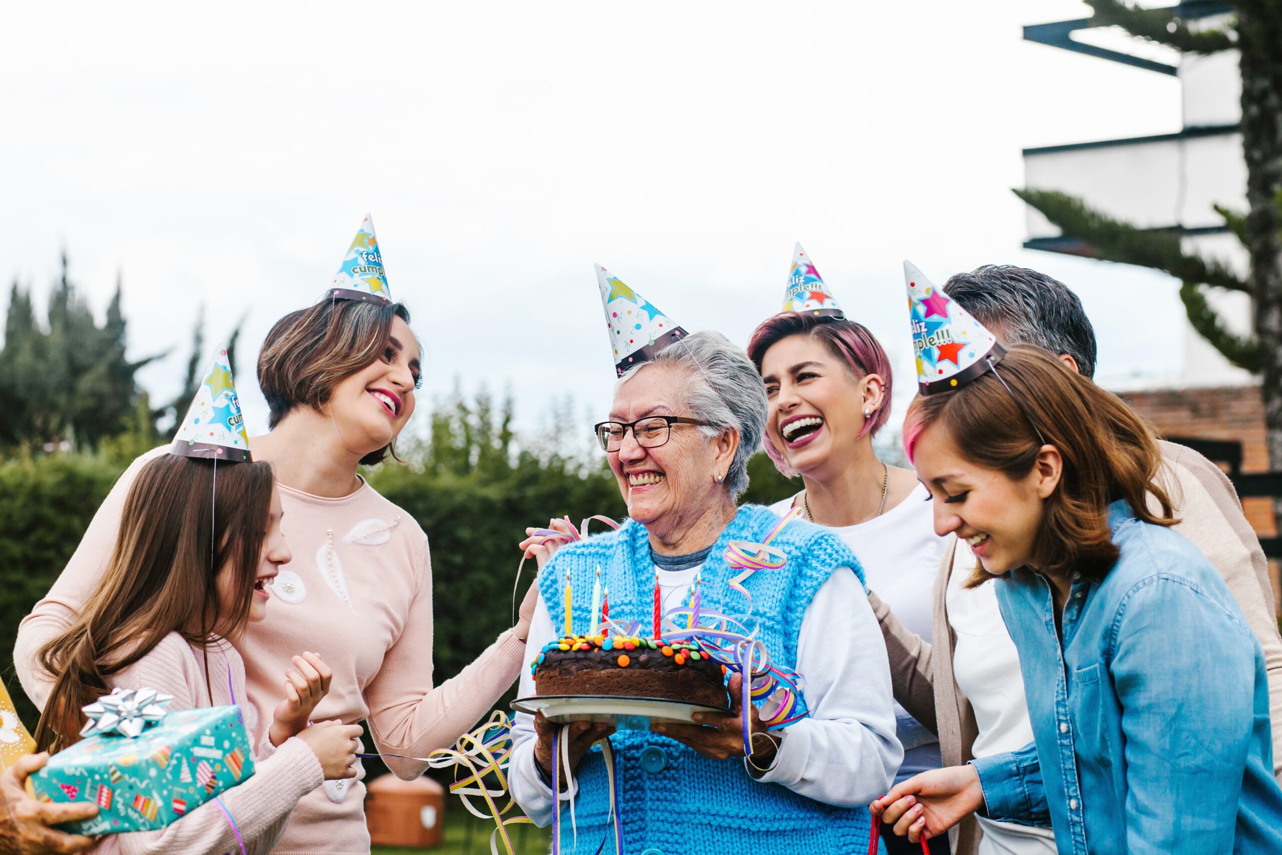 Mom holding a birthday cake surrounded by family