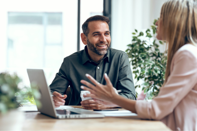 Two HR workers discussing the questions to ask in selecting an employee recognition software