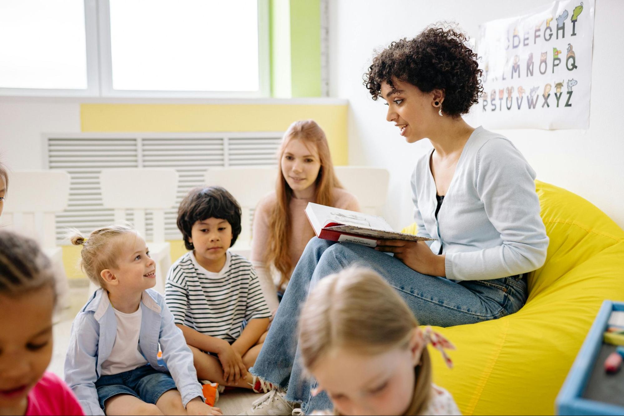 Teacher reading book to a group of students