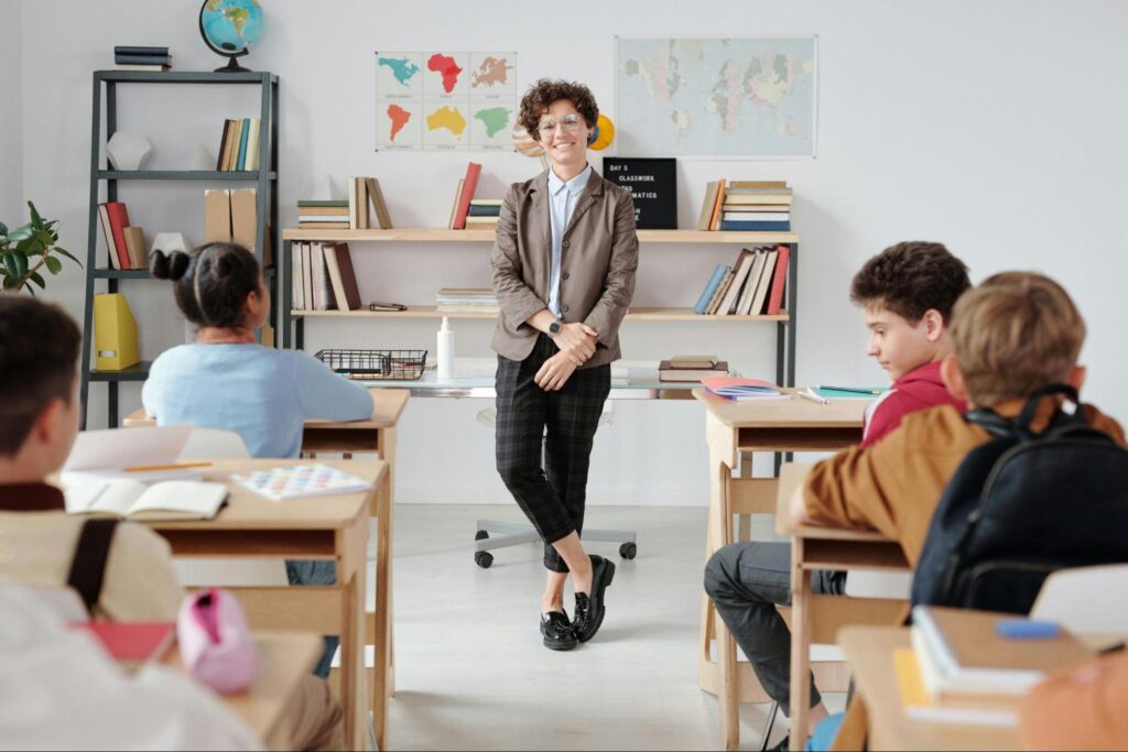 Smiling teach standing in front of a group of students